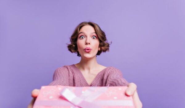 Woman posing with kissing face expression and holding gift