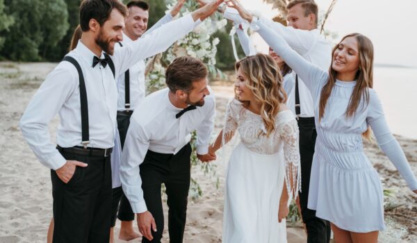 Beautiful bride and groom having their wedding with guests on a beach