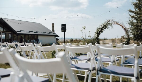 White chiavari chairs for guests, ceremonial wedding arch on the decorated for the wedding ceremony